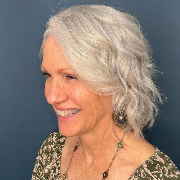 Natural Wavy Gray Hairstyles- a woman with gray hair wearing a a floral green blouse