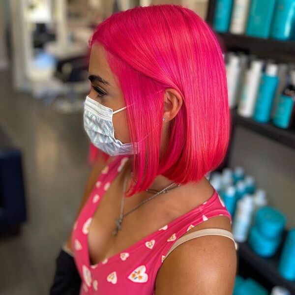 Neon Pink Hair Color- a woman wearing a white face mask and a pink blouse