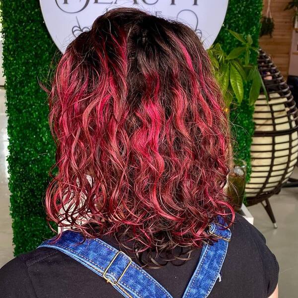 Nice Magenta Curls Hairstyle- a woman wearing a black shirt with a denim jumper