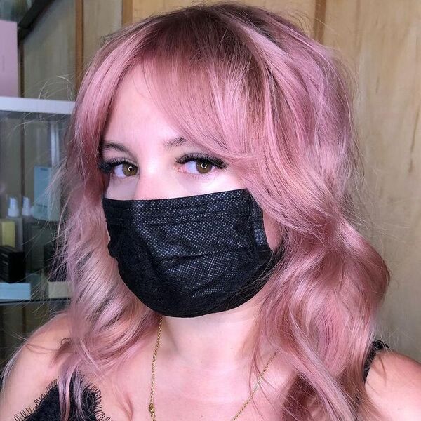 Pink Hair Color with Black Roots- a woman wearing a black face mask