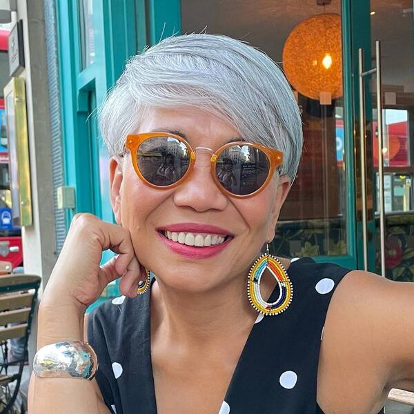 Pixie Haircut with Bangs for Growing Out Gray Hair- a woman with gray hair wearing a sunglasses