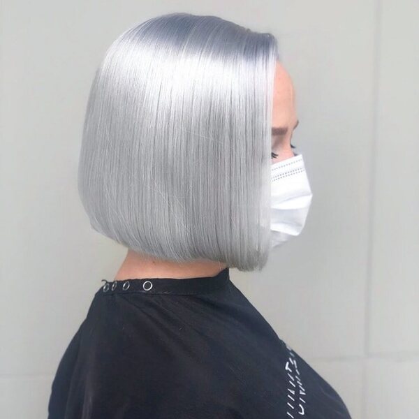 Platinum Blonde Bob Haircuts- a woman wearing a black barber's cape