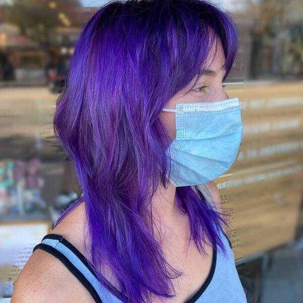 Purple Shag Hairstyle- a woman wearing a face mask and a blue camisole