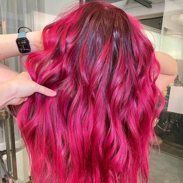 Red Roots with Pink Ends for Long Wavy Hair- a woman wearing a maroon shirt