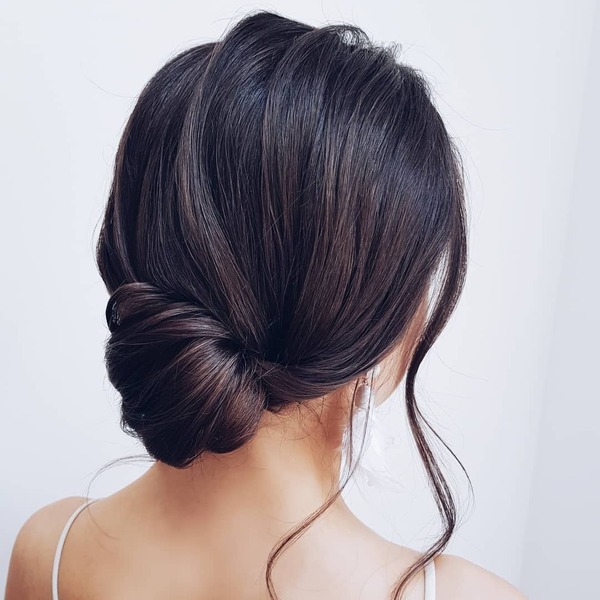 Romantic Loose Chignon Brunette Hairstyle- a woman wearing a white camisole