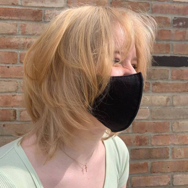 Round Shag Haircut- a woman wearing a black face mask