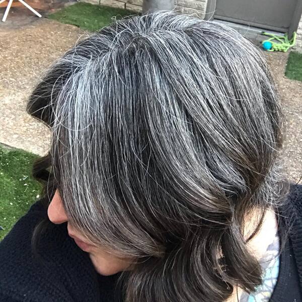 Salt'n Pepper Grown Out Hair- a woman with gray hair wearing a black sweater