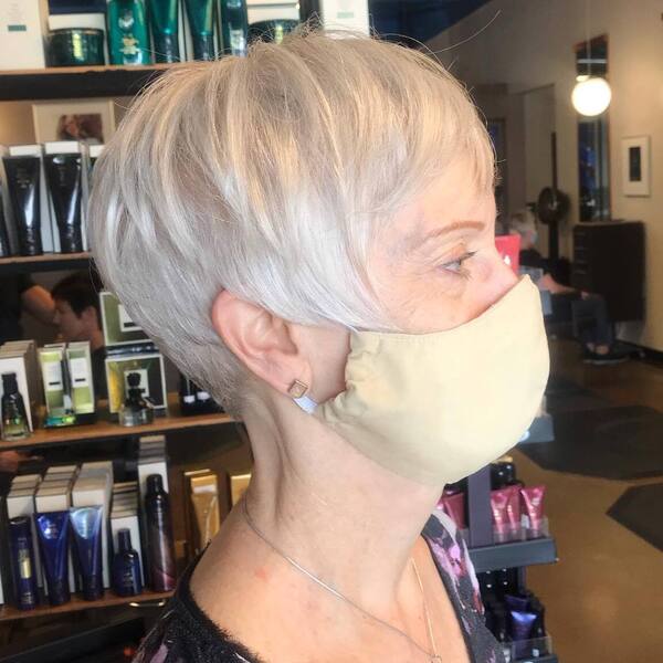 Sharp Long Pixie- a woman over 60 wearing a khaki face mask