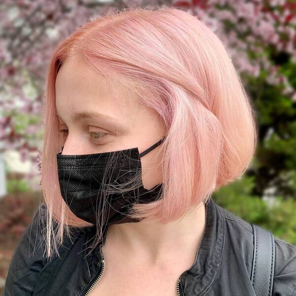 Short Bob for Women with Pink Hair Color- a woman wearing a black face mask