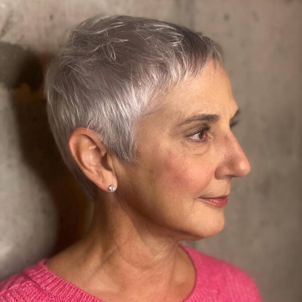 Short Pixie for Women with Natural Gray Hair- a woman with gray hair wearing a pink sweater