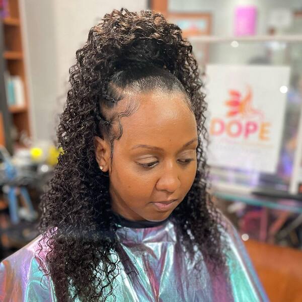 Side Braids with Ponytail Weave- a woman wearing a barber's cape