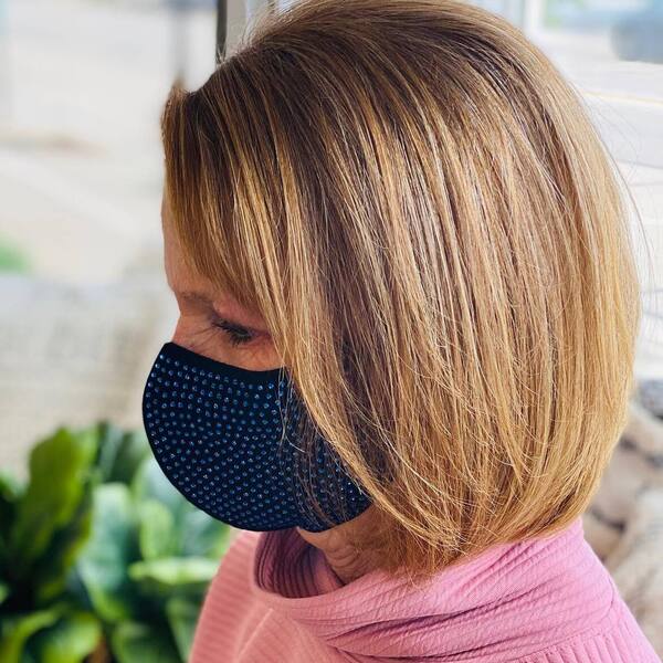 Side Parted Bob- a woman wearing a black face mask and a pink turtle neck sweater