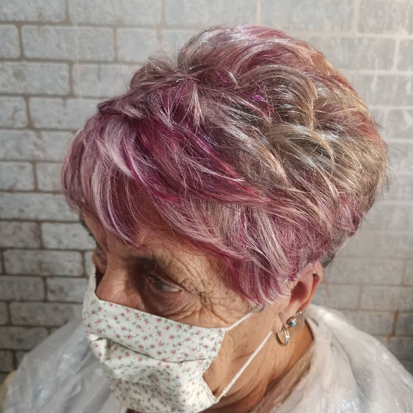 Streak of Pink Pixie- a woman over 60 wearing a white face mask