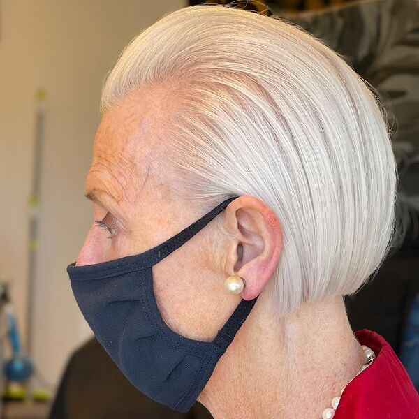 Swept Back Hairstyles for Women Over 60- a woman over 60 wearing a black face mask