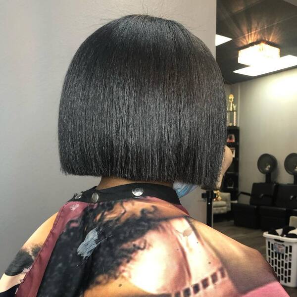 Thick Bob for Black Women- a black woman wearing a barber's cape