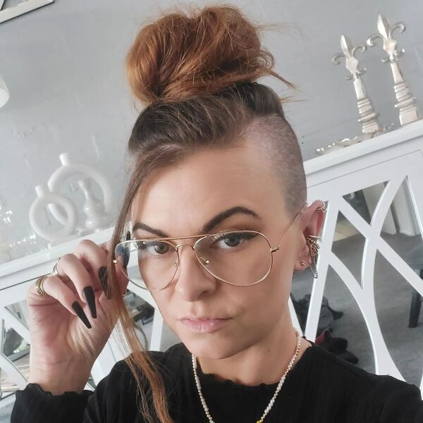 Top Bun with Shave Sides- a woman wearing a black blouse