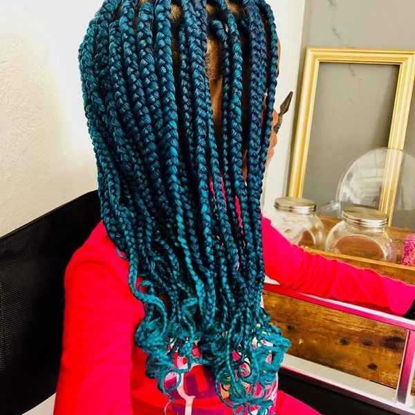 Turquoise Box Braids with Curly Tips- a woman wearing a red sweater