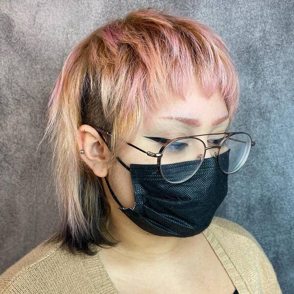 Undercut Shag Haircut- a woman wearing a black face mask