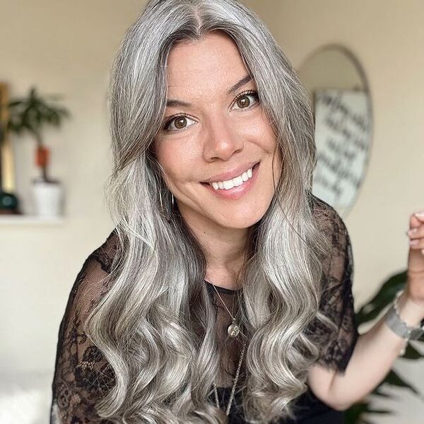 Wavy Long Hairstyle for Growing Out Gray Hairs- a woman with gray hair wearing a black blouse
