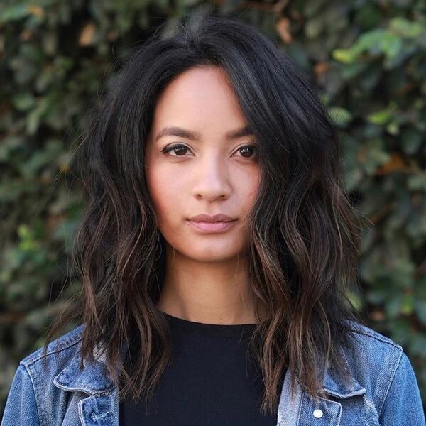 Wavy Shoulder-Length Hairstyles for Square Faces - a woman wearing a denim jacket