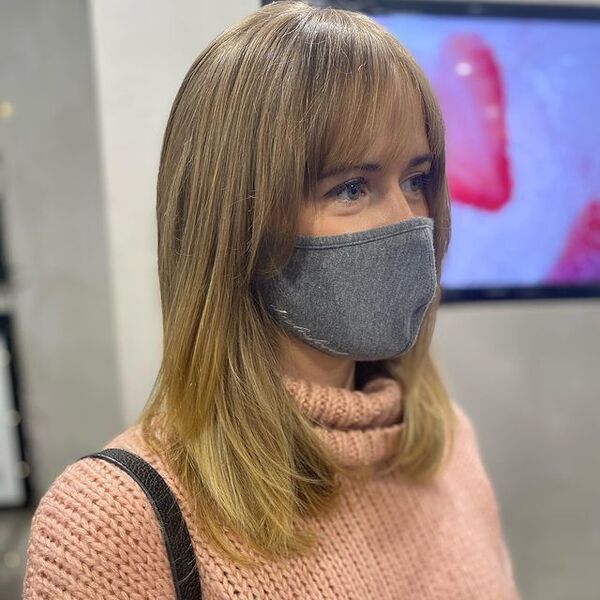 Barely Visible Layered Hairstyle - a woman wearing a face mask