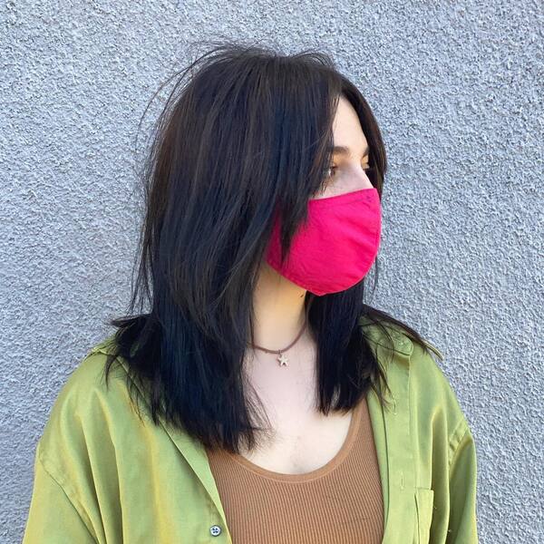 Billie Eilish inspired Layered Haircuts - a woman wearing a pink face mask