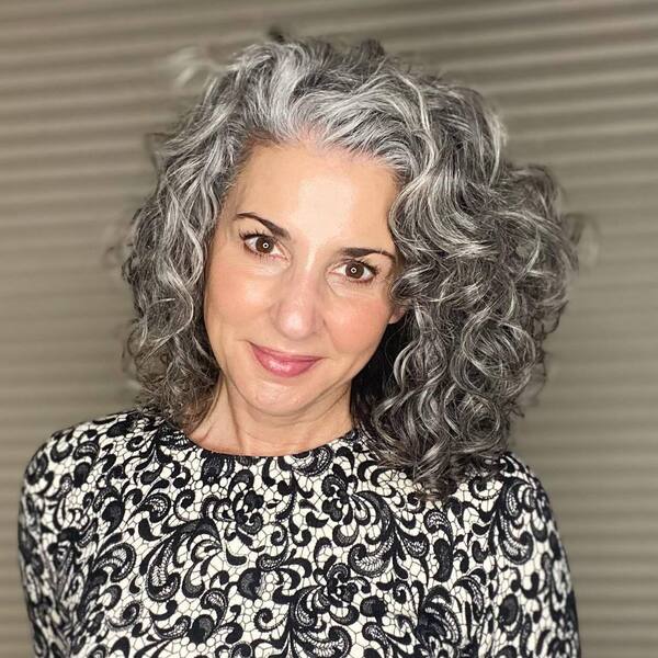 Curly Hairstyle for Gray Hair- a woman wearing a white blouse dress