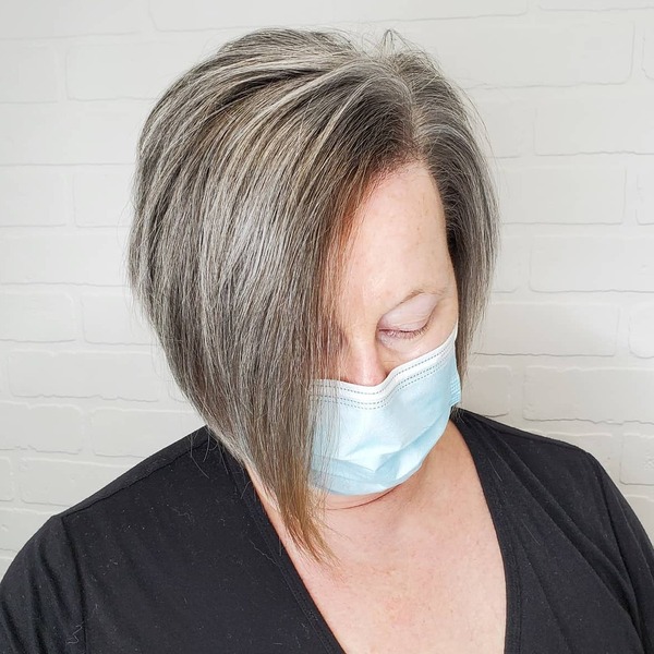 Gray Hair Color Lopsided Bob- a woman wearing a face mask and a black shirt