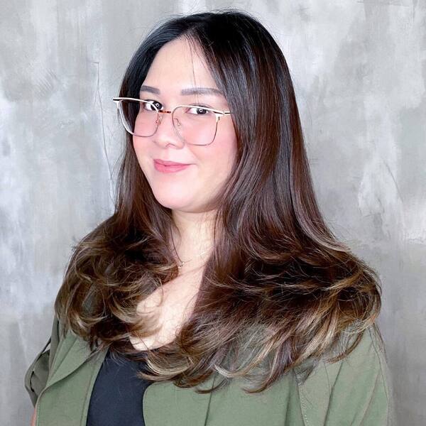 Layered Hairstyles for Round Faces- a woman wearing an eyeglasses