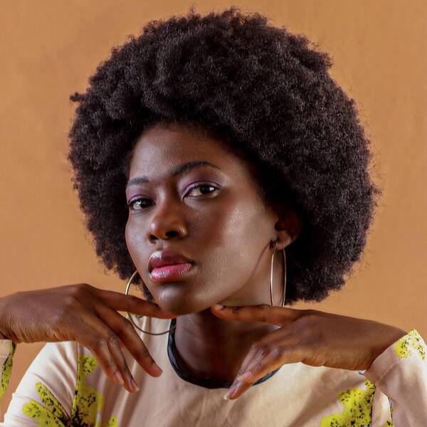 Natural Afro Hairstyle for Round Faces- a woman wearing a white sweater dress