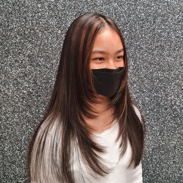 Sharp Angles Layered Hairstyles - a woman wearing a black face mask