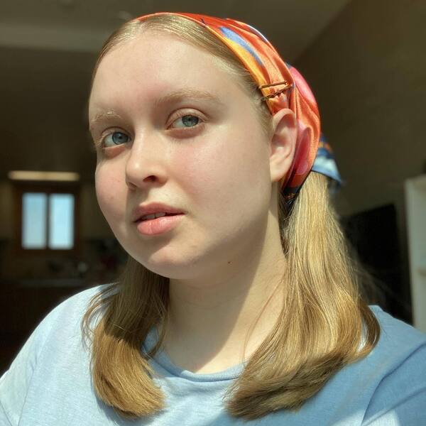 Shoulder Length Haircuts for Round Faces- a woman wearing a headband and a light blue t-shirt