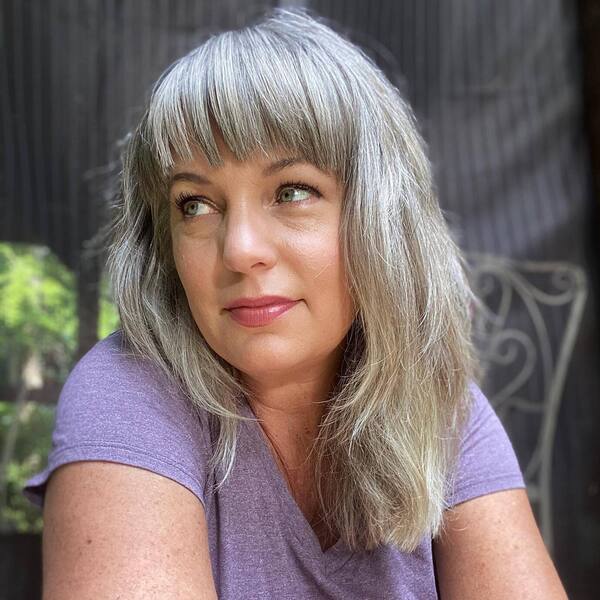 Silver Bangs for Gray Hair Color- a woman wearing a purple t-shirt