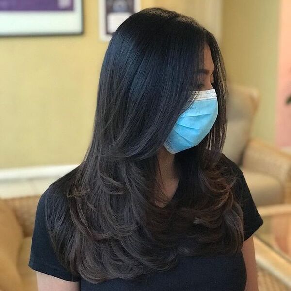 Soft Layered Haircuts for Long Hair -a woman wearing a face mask and a black shirt