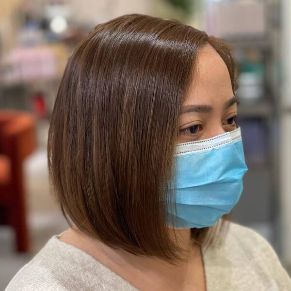 The Bob Haircuts for Round Faces- a woman wearing a face mask