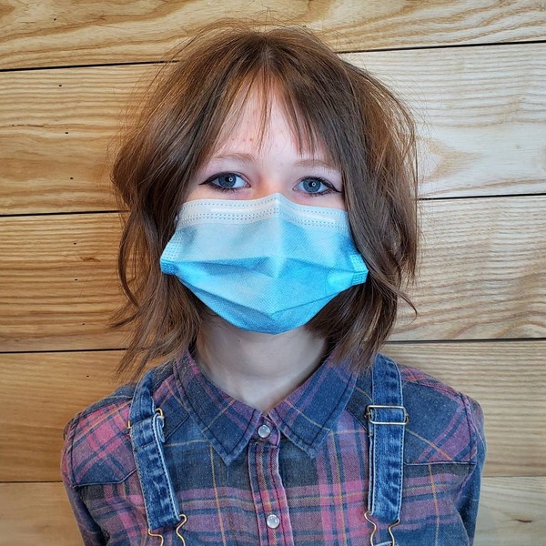Thinned Out Bangs- a woman wearing a face mask